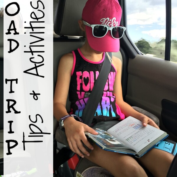 Child wearing sunglasses and a cap reads a book in a car seat. Text overlay says Road Trip Tips & Activities for Kids.