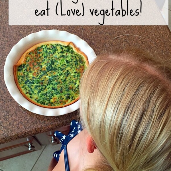 A child gazes at a spinach quiche in a pie dish on the counter, with text above reading "Mastering the art of getting kids to eat vegetables!