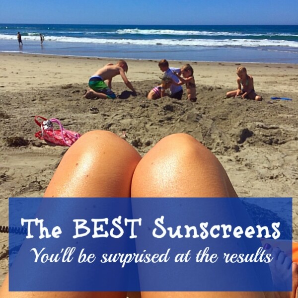 People enjoy a sunny beach day; a person’s legs in the foreground and a family playing in the sand in the background, with text promoting sunscreens boasting the best sunscreen ratings.