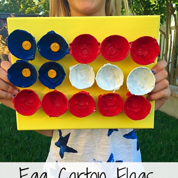 A child proudly holds an art piece crafted from a yellow board, featuring red, white, and blue egg carton halves carefully arranged as a vibrant flag—a delightful example of crafts with egg cartons.