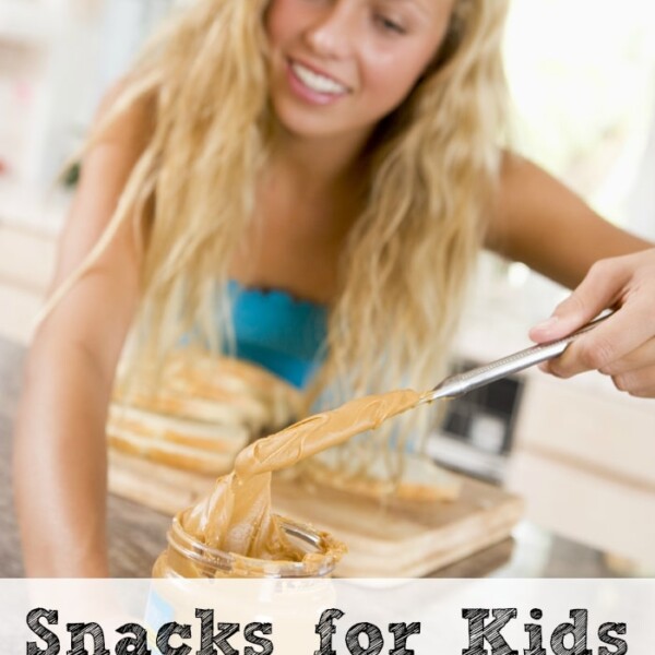 Person spreading peanut butter from a jar, with the text After School Snacks for Kids with peanut butter on the image.