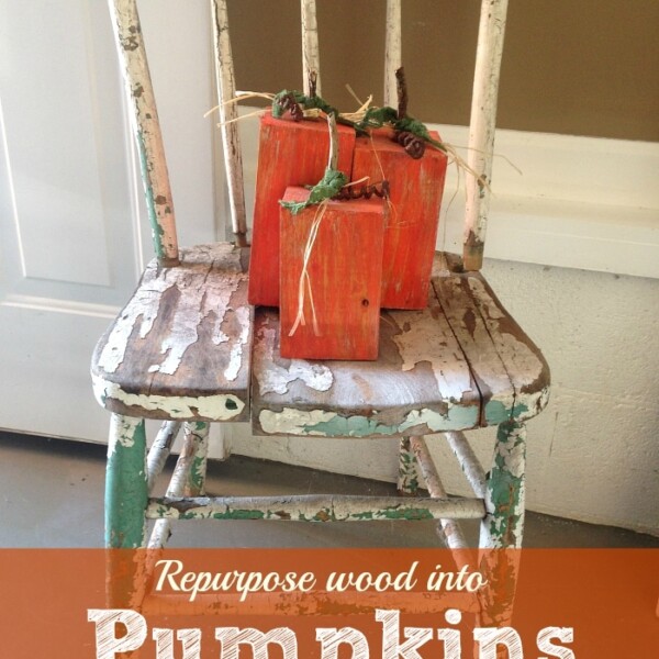 A distressed wooden chair holds three wooden blocks painted orange and styled as pumpkins, perfect for Halloween home decorating ideas. The text reads: Repurpose wood into Pumpkins.