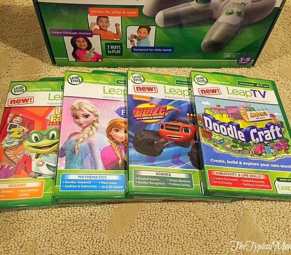 Four LeapTV game cases featuring characters from LeapFrog, Frozen, Blaze, and DoodleCraft are displayed on a beige carpet.