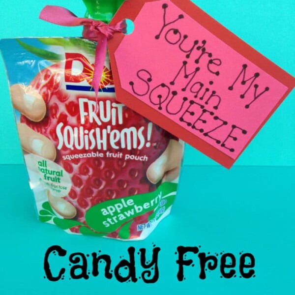 Squeezable fruit pouch with a red tag saying You're My Main Squeeze, perfect for valentine ideas for kids. Text below reads Candy Free Valentine on a teal background.