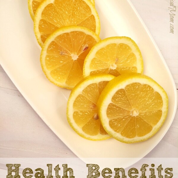 Sliced lemons arranged on a white plate with the text highlighting their impressive lemon health benefits below.