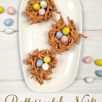 Three butterscotch haystacks adorned with colorful candy eggs rest gracefully on a white rectangular plate.