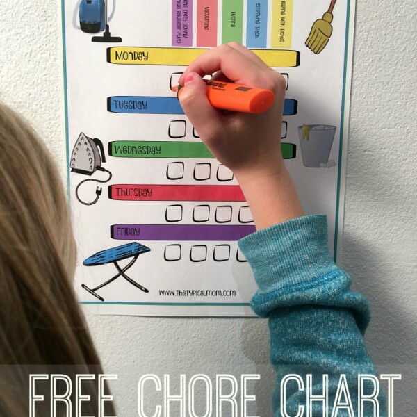 A child enthusiastically uses an orange marker to fill out a vibrant chore chart on the wall, titled 2-A-Day Chore Chart, with days of the week and tasks clearly listed. Discover free printable chore charts to make organizing chores fun for kids!