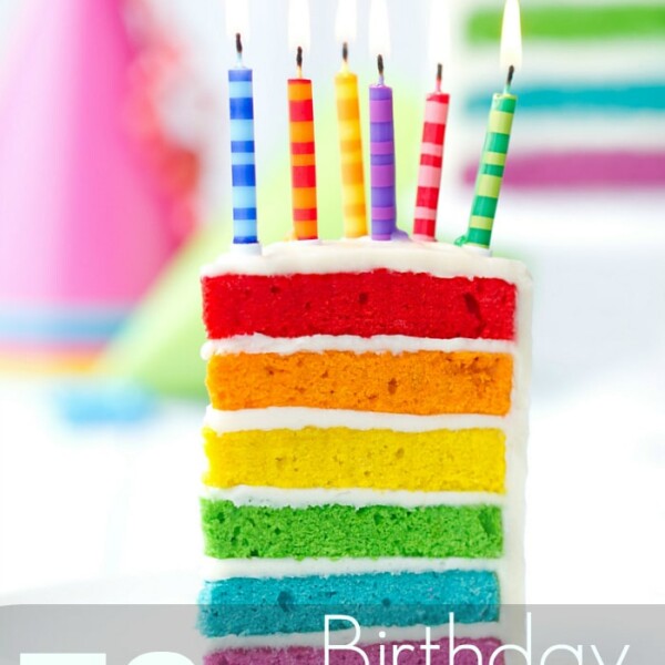 A slice of rainbow layered cake with six lit striped candles takes center stage, framed by a softly blurred party hat in the background. Text overlay at the bottom reads, "70+ birthday freebies," ensuring your special day is filled with delightful surprises.