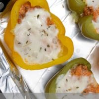 Lasagna stuffed bell peppers brimming with savory lasagna filling and crowned with melted cheese rest perfectly on a foil-lined tray.