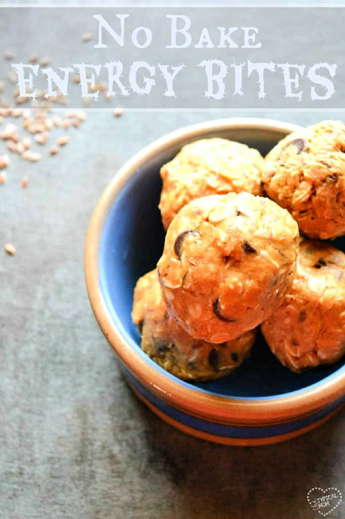 Really easy energy ball recipe with chocolate chips and hidden flax seeds and healthy. Kids and adults love these no bake energy balls. A blue bowl filled with no-bake energy bites sits on a gray surface, with text above reading No Bake Energy Bites—a simple and delicious energy ball recipe perfect for quick snacks.