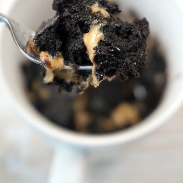 A spoonful of chocolate and peanut butter brownie being lifted from a mug offers a delightful twist on how to make a brownie in a mug.