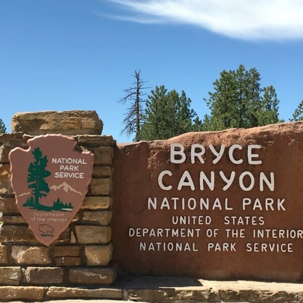 Entrance sign for Bryce Canyon National Park, Utah, proudly displaying the National Park Service emblem.