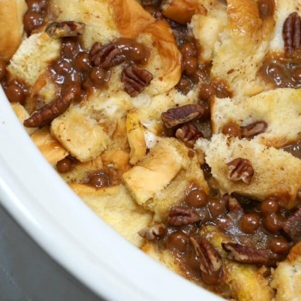 Close-up of a crockpot French toast casserole, transformed into a delightful bread pudding with pecans and caramel sauce.