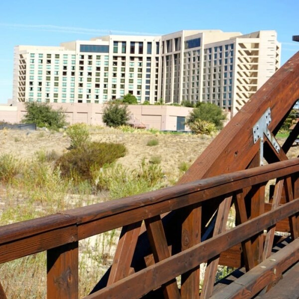 A wooden bridge stretches gracefully, with the Pechanga Resort and Casino's modern architecture standing proudly under a clear blue sky.