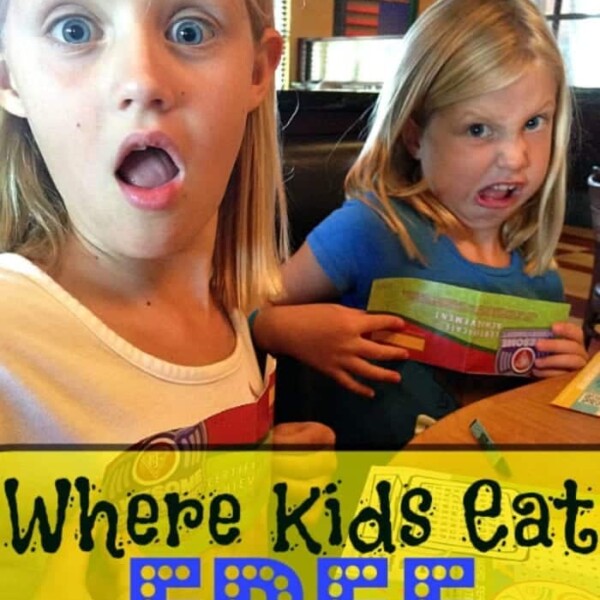 Two young girls with surprised expressions sit at a table in a bustling restaurant. One is dressed in a crisp white shirt, while the other sports a cheerful blue one. A yellow banner below proudly announces this as the place where kids eat free, adding to their joy.