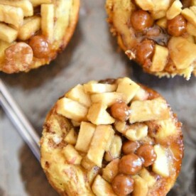 A delightful display of three mini caramel apple pies, featuring diced apples and rich caramel, elegantly presented on a silver tray—perfect for those seeking a delectable recipe for mini apple pies.