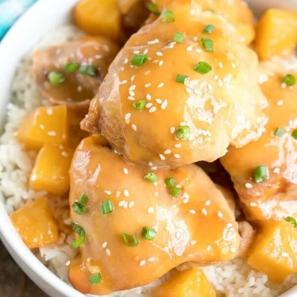 Easy pineapple chicken served in a bowl features tender glazed chicken with juicy pineapple chunks and vibrant green onions, all atop a fluffy bed of rice.