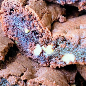 Close-up of decadent chocolate brownies made from devil's food cake mix, with visible chunks of nuts inside.