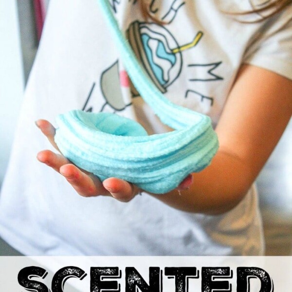 A child gleefully plays with blue slime, its delightful texture paired with the sweet aroma of scented cotton candy.