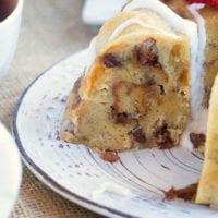 A slice of decadent bread pudding with white icing sits gracefully on a decorative plate, crowned with sweet strawberry slices&mdash;a delightful treat that rivals even the richest instant pot bread pudding.