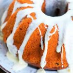 Bundt cake with white icing drizzled on top, crafted to perfection in a Ninja Foodi, served elegantly on a white plate.