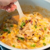 Serving a cheesy pasta dish with corn, beans, and green onions straight from the pressure cooker, this flavorful meal brings a hint of Mexican casserole flair.