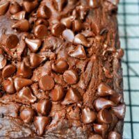 A close-up of chocolate chip pumpkin bread on a cooling rack, resembling a delectable slice of chocolate pumpkin cake.