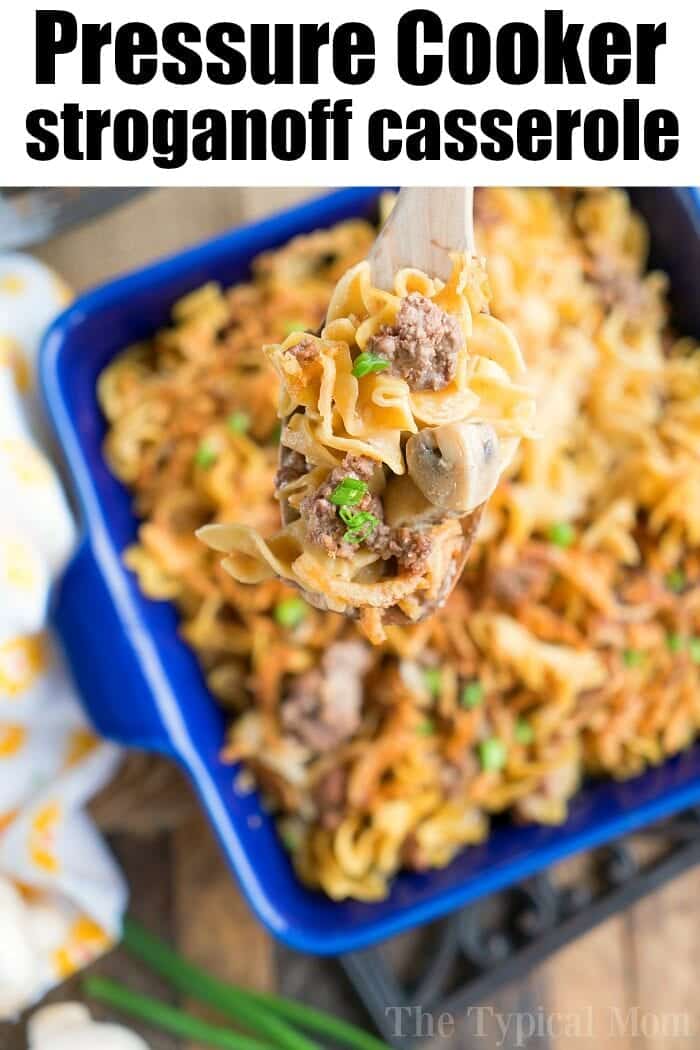 A blue dish cradles a savory serving of pressure cooker stroganoff casserole—noodles, meat, mushrooms, and peas melded in harmony. A wooden spoon gracefully lifts a portion from the dish. Text above warmly invites: "Pressure Cooker Stroganoff Casserole.