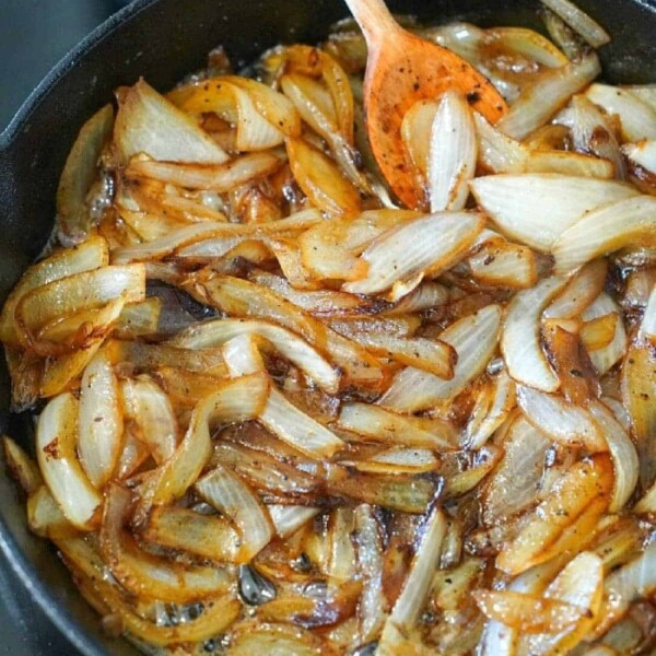 Caramelized onions with brown sugar on stove simmer nicely in the skillet, stirred gently with a wooden spoon.