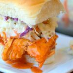 Instant Pot buffalo chicken slider with coleslaw elegantly presented on a square white plate.