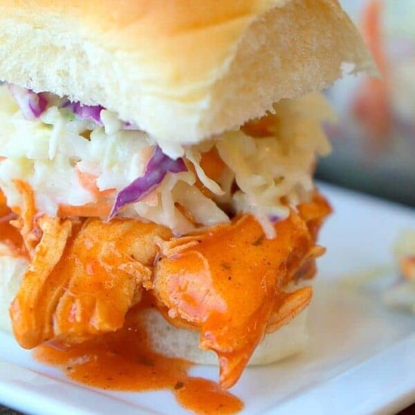 Instant Pot buffalo chicken slider with coleslaw elegantly presented on a square white plate.