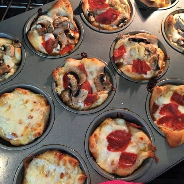 Savor the delightful aroma of pizza muffins as mini pizzas with assorted toppings like pepperoni and mushrooms bake to perfection in a muffin tin.