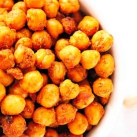 A close-up view of a bowl filled with golden brown, crispy air fryer chickpeas, perfectly roasted and seasoned to perfection.