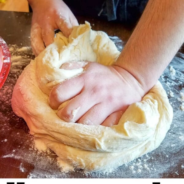 A person skillfully kneads dough on a floured surface, embodying the comforting art of baking homemade white bread.