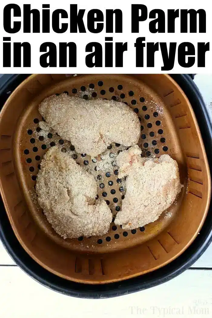 Air fryer basket with three breaded chicken breasts, perfectly cooked and labeled "Air Fryer Chicken Parm" at the top.