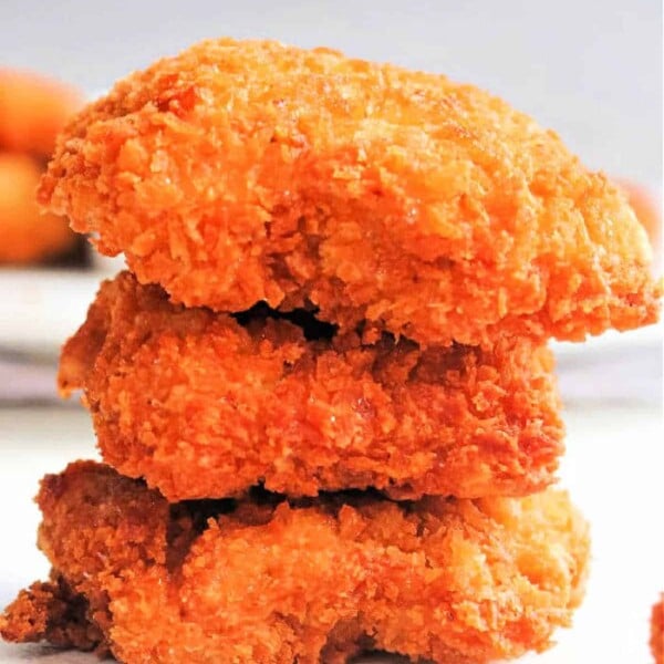 Three stacked homemade chicken nuggets made with ground chicken on a white background.