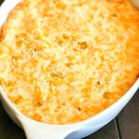 A baked casserole dish filled with creamy, golden-brown cheesy hash brown potatoes, enhanced by the savory flavors of green chile chicken.