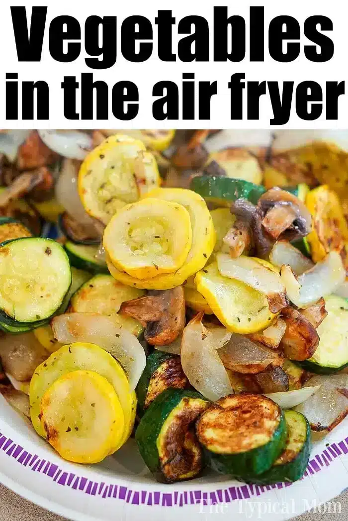 A plate of air-fryer vegetables, featuring sliced zucchini, yellow squash, onions, and mushrooms, is displayed. The text above reads "Deliciously crisp air fryer vegetables.