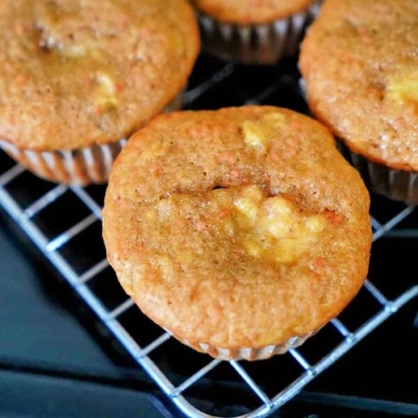 Close-up of freshly baked 4 ingredient banana bread muffins with a golden-brown top, cooling on a wire rack.