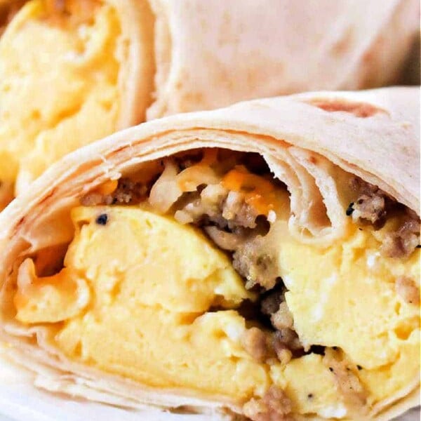 Close-up of breakfast burritos, perfectly cooked in an air fryer, filled with scrambled eggs and sausage.