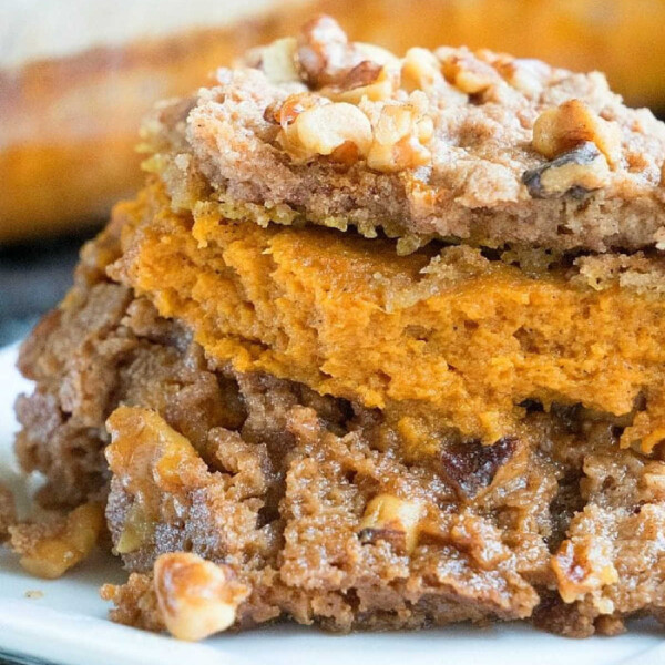 Close-up of an easy pumpkin dessert: a delectable pumpkin dump cake topped with chopped walnuts, elegantly presented on a white plate.