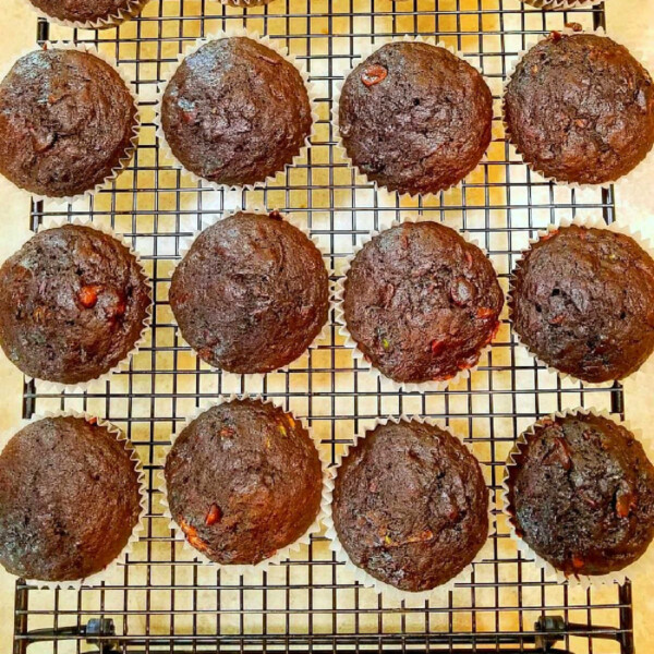 Chocolate banana muffins cooling on a wire rack, arranged in rows.