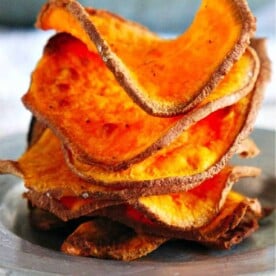 A stack of crispy, air-fried sweet potato chips on a plate.