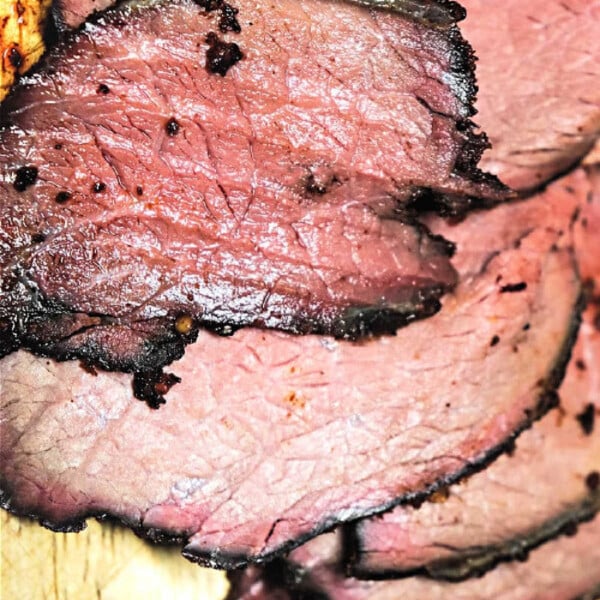 Slices of tender sirloin tip roast, slow-cooked to perfection in an Instant Pot, rest gracefully on a wooden cutting board.