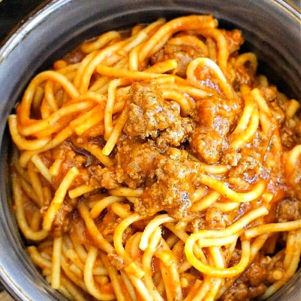 A bowl of instant pot spaghetti with ground meat in tomato sauce.