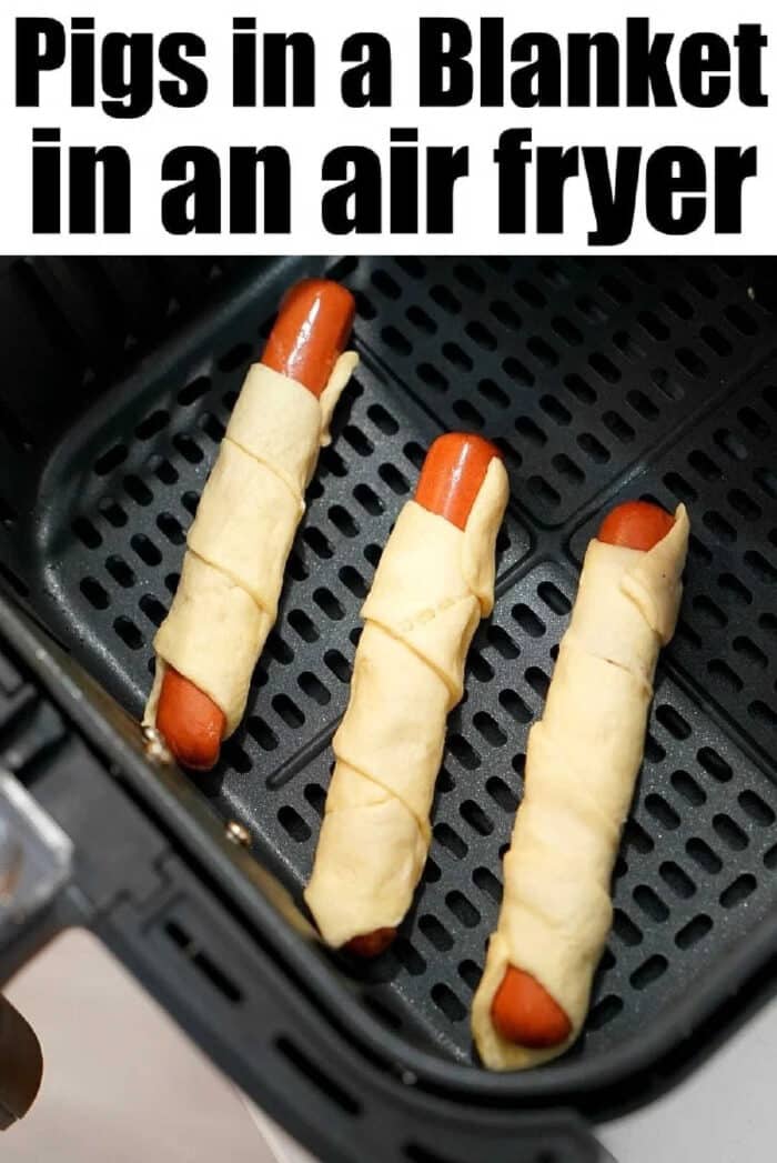 Air fryer pigs in a blanket are my kids favorite snacks! Easy recipe to make with crescent rolls and hot dogs that turns out crunchy to perfection every time. Three air fryer pigs in a blanket sit perfectly arranged in the basket, ready to be cooked to golden perfection.