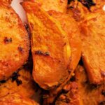 Close-up of air fryer sweet potato wedges with crispy edges and seasoning.