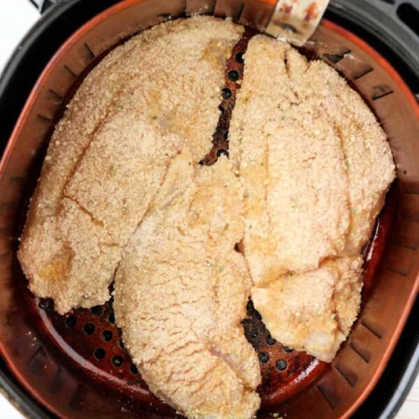 Breaded fish fillets rest in the air fryer basket, ready to become a delicious part of your favorite air fryer fish recipes.