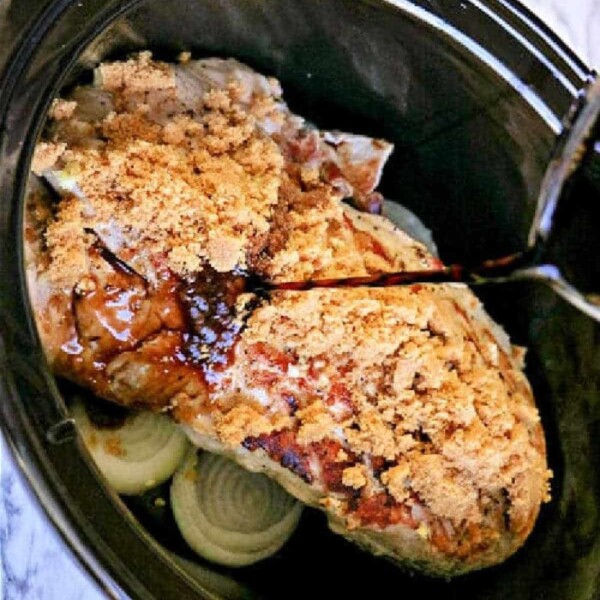 Experience an amazing pork tenderloin slow cooker recipe with a savory roast, layered with sliced onions, topped with brown sugar, and finished by pouring over your favorite liquid.