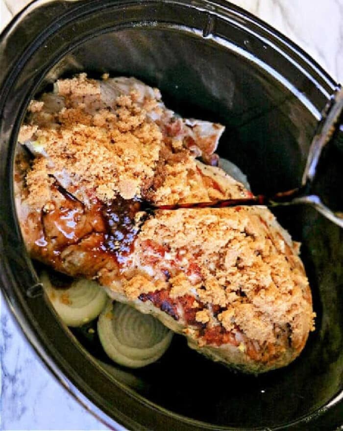 Experience an amazing pork tenderloin slow cooker recipe with a savory roast, layered with sliced onions, topped with brown sugar, and finished by pouring over your favorite liquid.